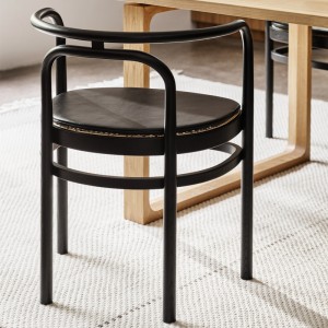 Imagen ambientada comedor Silla PK15 en fresno lacado negro con cojín de asiento cuero Grace black de Fritz Hansen